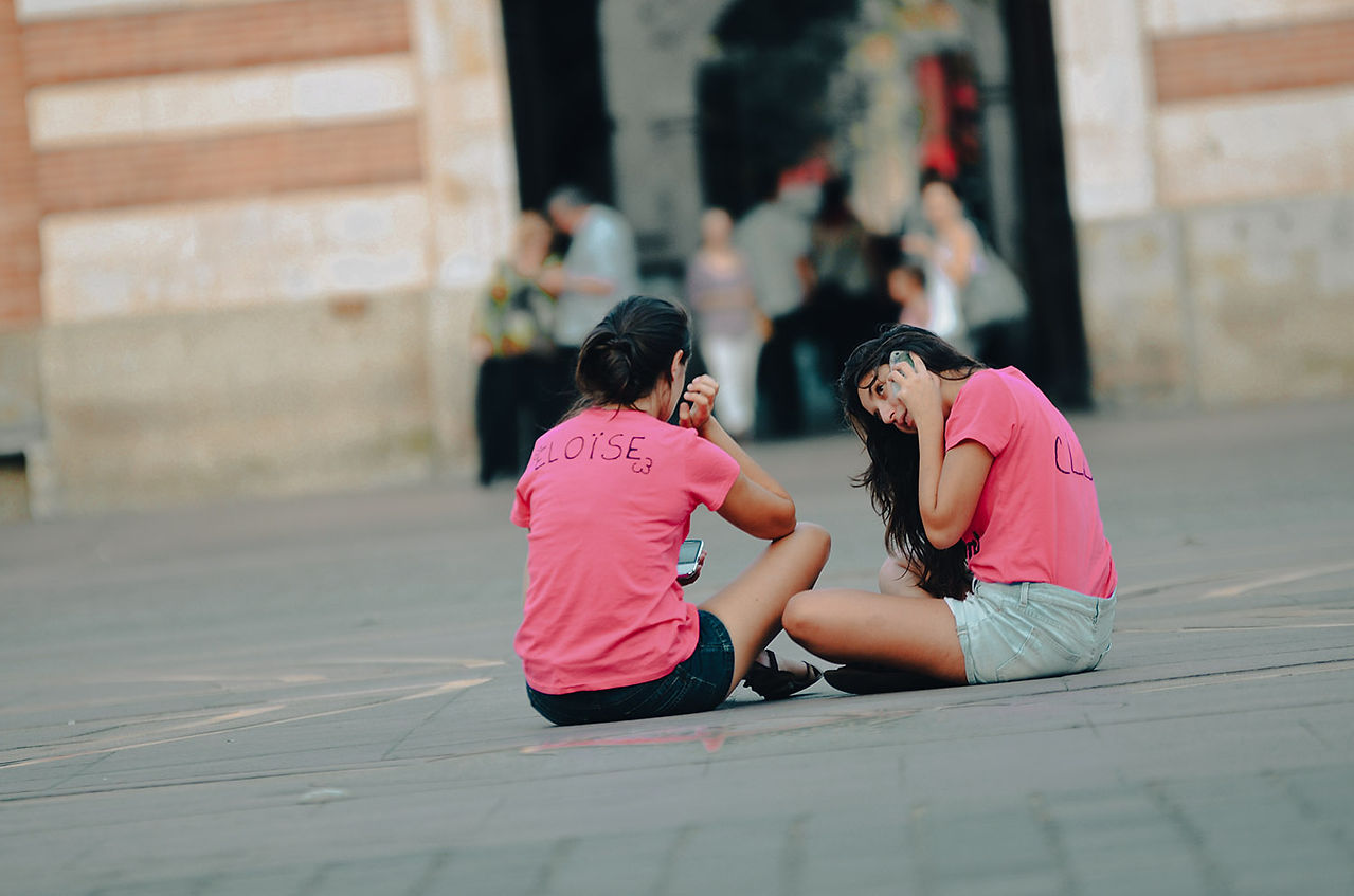 Deux femmes en t-shirt rose assises sur une place à Toulouse.