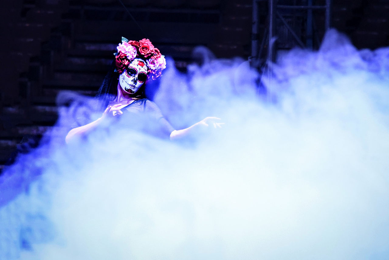 Artiste du Cirque Infernal maquillée en crâne dans la brume.