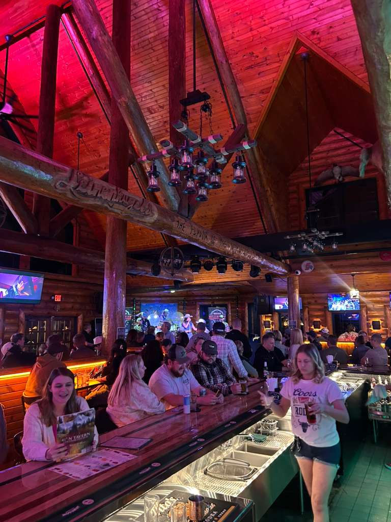 Eye-level view of a cozy tavern interior with wooden tables and dim lighting