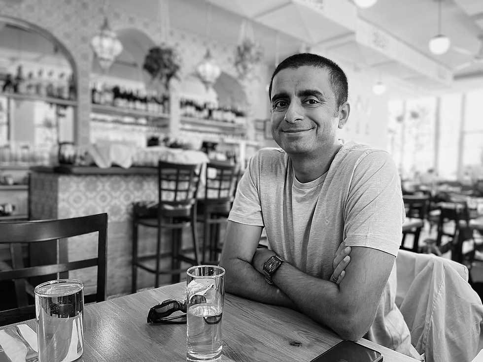 Black and white portrait of the author seated at a table in a cafe