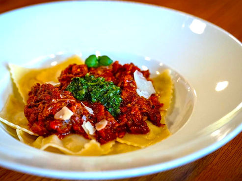 An elegant plate of braised short rib and ricotta-stuffed ravioli