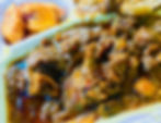 A takeout container filled with rich curried goat in gravy with plantains from Karubee's Jamaican Cuisine.