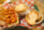A basket featuring bowls of gumbo and etouffee, with a shrimp po'boy sandwich from Bourbon Street Bistro in Charleston, WV
