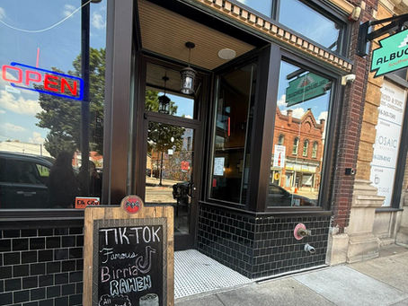 A restaurant storefront with a sign out front