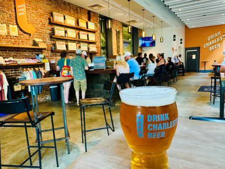 A pint of beer sits on a table with a taproom in the background at Fife Street Brewing in Charleston