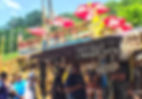 People standing in line at a roadside hot-dog stand