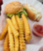 A basket of food with a hot dog, cheeseburger and crinkle-cut fries