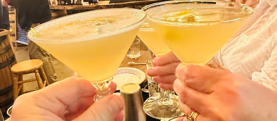 Three bright yellow cocktails in martini glasses are toasted during a cocktail-making class at The Bullock Distillery in Charleston, WV
