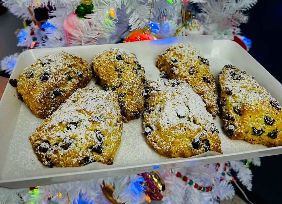 Sugar-dusted scones sit on a platter in front of a decorated Christmas tree