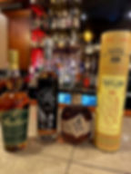 Four bottles of high-end bourbon sitting on a bar