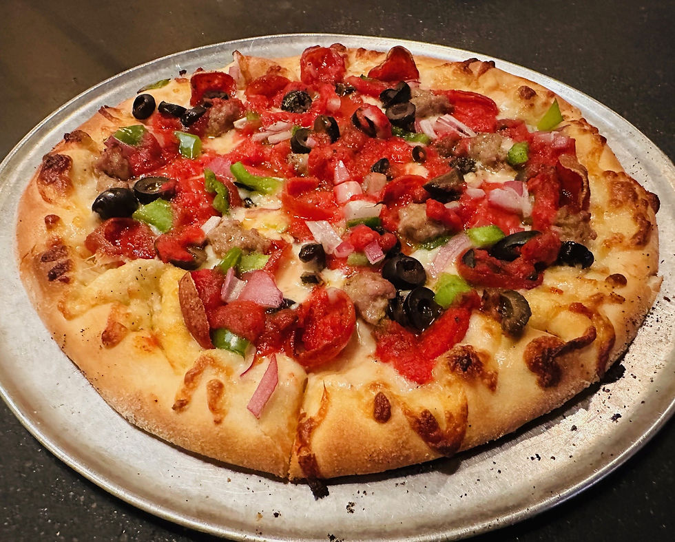 A traditional pizza topped with meats, green peppers, mushrooms and onions