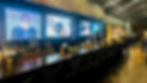 A long bar with large TVs in the background