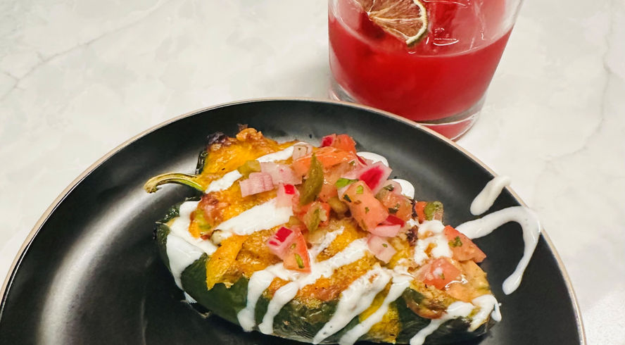 A stuffed poblano pepper sits on a plate with a colorful blackberry margarita from Ursus Brew Works in Charleston, WV