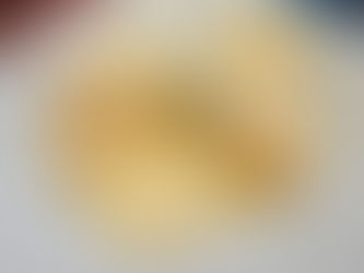 A plate of shrimp ravioli covered in cream sauce with cheese