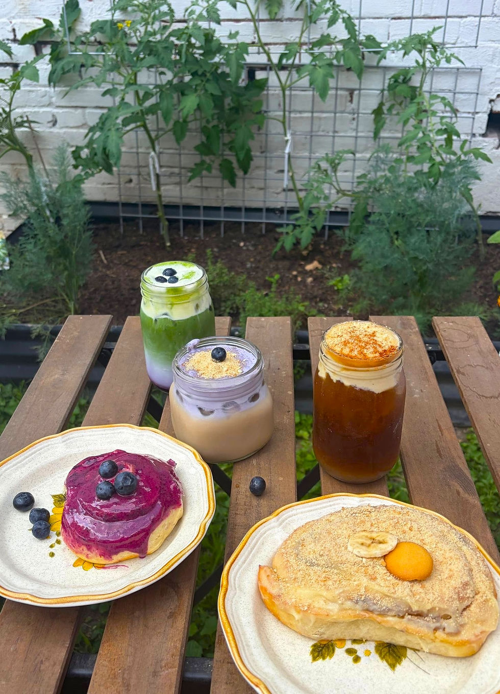 A table is filled with assorted treats and coffee, tea and fruit drinks in the outdoor area of Goldenrod Kitchen in Charleston, WV