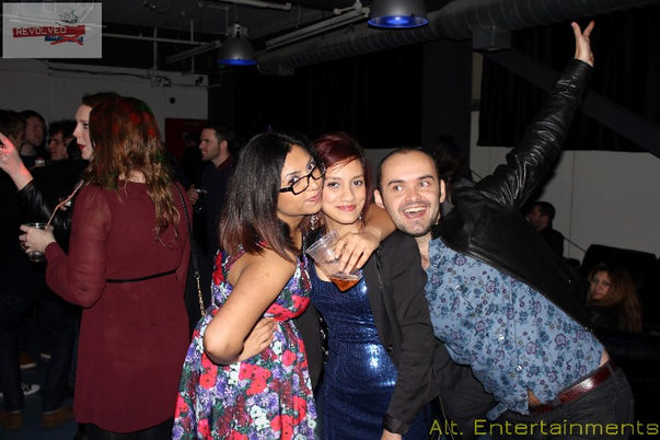 A group of people posing for a photo at the Revolved Indie Night Reunion, which was held at Fixxion Warehouse in Wolverhampton. The event, previously hosted at the Light Bar, is captured by Alt. Entertainments, a mobile DJ and events company. The attendees are smiling and enjoying the moment, reflecting the festive and energetic atmosphere of the reunion in the spacious and modern setting of Fixxion Warehouse.
