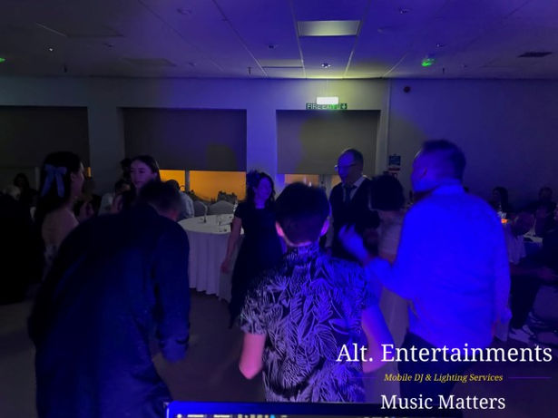 Wedding guests dancing energetically at Wolverhampton Lawn Tennis & Squash Club in Tettenhall, with vibrant lighting and festive decor. Photo by Alt. Entertainments Wedding DJ/Mobile DJ, Disco & Events Company.