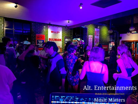 A vibrant crowd dances energetically at a birthday party disco hosted by Alt. Entertainments at The Crown Joules, Codsall, Wolverhampton. The venue is alive with excitement as guests of all ages enjoy the lively atmosphere and dynamic music, creating an unforgettable celebration.