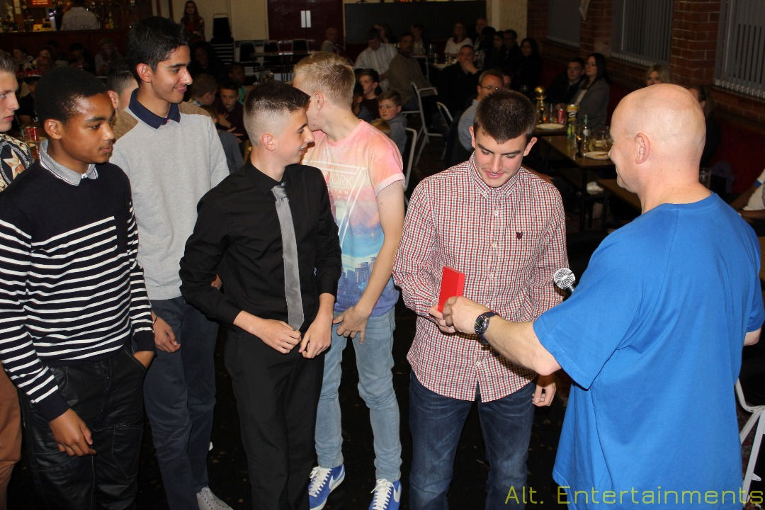 Award winners on stage at a football awards evening at Spring Meadow Social Club in Cradley Heath, proudly accepting their trophies. Organized by Alt. Entertainments, a mobile DJ, disco, and events company, the image shows the recipients smiling and posing with their awards as an enthusiastic audience applauds in the background, celebrating their achievements.