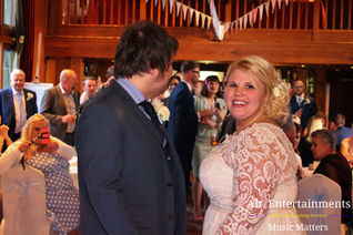 A heartwarming scene unfolds as the bride and groom share their first dance at Hundred House, Telford/Bridgnorth, Shropshire. Illuminated by disco lights, they radiate love and happiness. Photographed by Alt. Entertainments Wedding DJ / Mobile DJ, Disco & Events.