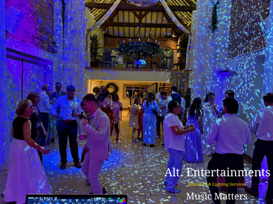 Wedding guests dancing and celebrating during an evening reception at The Barns at Delbury Hall near Craven Arms, Shropshire, photographed by Alt. Entertainments.