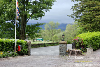 A stunning photo of Lodore Falls Hotel & Spa in the Lake District, Cumbria, showcasing its elegant architecture and lush grounds, ideal for a wedding reception. The image highlights the hotel's picturesque setting, surrounded by mountains, gardens, and the nearby waterfall. This venue is enhanced by the services of Alt. Entertainments Wedding DJ/Mobile DJ, Disco & Events Company.