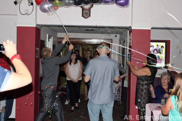 A bustling crowd celebrating a birthday party at the West End Club in Merridale, Wolverhampton. The photo, taken by Alt. Entertainments, shows guests dancing and enjoying the lively atmosphere. The function room is decorated with festive elements and vibrant lighting. The mobile DJ setup, provided by Alt. Entertainments, is visible in the background, contributing to the energetic vibe of the party. The image captures the joyful engagement of the guests and the professional execution of the event.