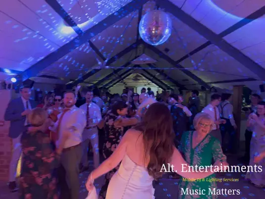 Wedding guests dancing and celebrating at Grangefields Barn in Ashbourne, Derbyshire, with professional DJ entertainment by Alt. Entertainments.
