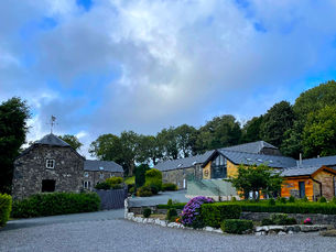 A row of charming stone holiday cottages at Gellifawr Woodland Retreat, Fishguard, Wales. Surrounded by lush greenery, these cottages provide a peaceful and rustic retreat for guests, blending traditional Welsh architecture with modern comforts. Photo taken by Alt. Entertainments.
