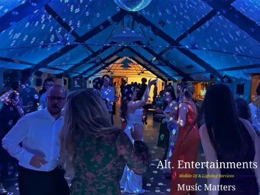 Wedding guests dancing joyfully at Grangefields Barn, Ashbourne, Derbyshire, with professional DJ and entertainment by Alt. Entertainments.