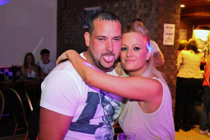 A vibrant crowd gathers at Studley Cricket Club in Redditch, Worcestershire, celebrating a birthday in style. Expertly photographed by Alt. Entertainments, a mobile DJ, disco, and events provider, the scene is alive with colorful decorations and infectious joy.