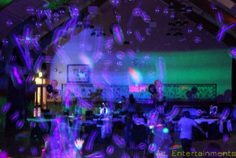 UV bubbles glowing brightly under ultraviolet lighting at Middlewich Civic Hall, Cheshire. The photo, taken by Alt. Entertainments, illustrates the magical effect of the bubbles, highlighting the mobile DJ, disco, and events company's ability to create an enchanting atmosphere at their events.