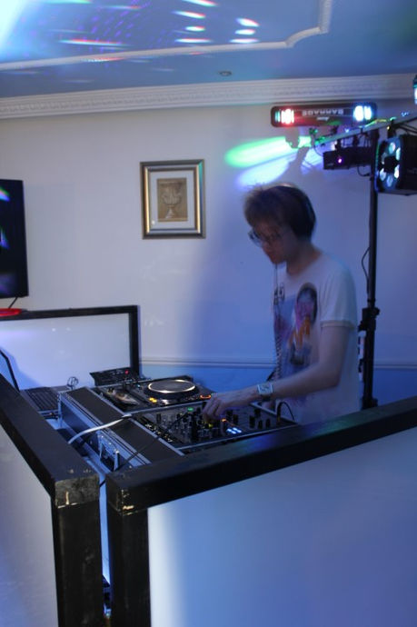A mobile DJ commands the turntables, enveloping the crowd in a whirlwind of rhythm and melody at Solihull Moors Football Club, captured by Alt. Entertainments, a mobile DJ & Disco Company.