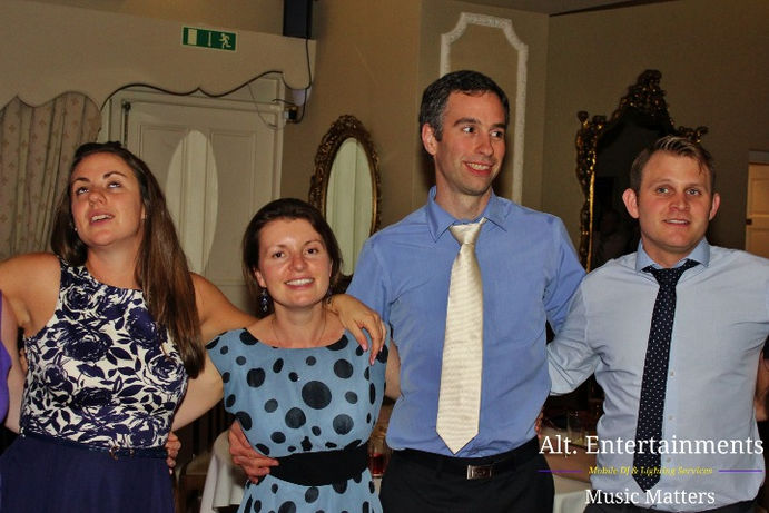 Bride and groom share their last dance at a wedding disco at Merewood Country House in the Lake District, Cumbria. The couple is surrounded by soft lighting and admired by their guests as they embrace and dance together. The photo, taken by Alt. Entertainments, a mobile DJ and events company, captures the emotional and intimate conclusion of the wedding celebration.