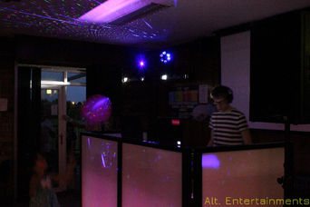 A DJ performing with a mobile DJ setup at Vipers RFC in Whetstone, Leicestershire. The photo, taken by Alt. Entertainments, showcases the dynamic atmosphere of their mobile DJ, disco, and events services, featuring colorful lights and energetic music.