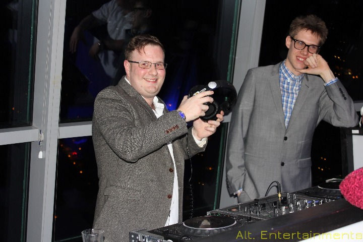 A DJ performing at The Sky Bar, formerly The Ramada and now a Holiday Inn in Cannock, surrounded by an energetic crowd, captured by Alt. Entertainments, a Mobile DJ, Disco & Events Company.