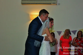 Bride and groom sharing their first dance at a wedding disco, illuminated by soft lighting at Mythe Barn in Atherstone, Leicestershire. Photo taken by Alt. Entertainments, a wedding DJ, mobile DJ, disco, and events company, capturing the romance and joy of this special moment.