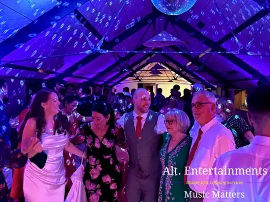 Wedding guests dancing and celebrating at Grangefields Barn, Ashbourne, Derbyshire, with professional wedding DJ and entertainment by Alt. Entertainments.
