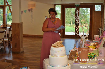 Elegant wedding table setting adorned with floral centerpieces and a stunning wedding cake at Mythe Barn in Atherstone, Leicestershire. Photo by Alt. Entertainments, a wedding DJ, mobile DJ, disco, and events company, capturing the beauty and joy of a wedding celebration.