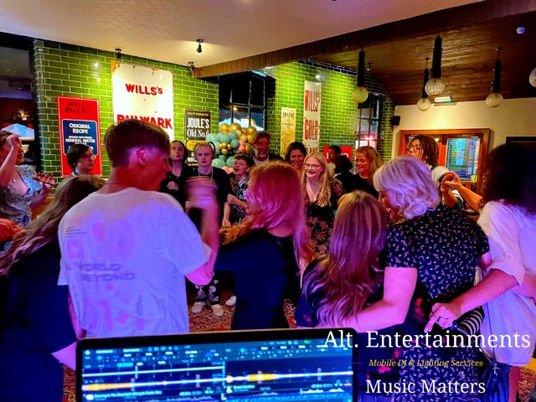 Energetic crowd dances to music at a birthday party disco hosted by Alt. Entertainments at The Crown Joules, Codsall, Wolverhampton, filling the venue with excitement and joy.