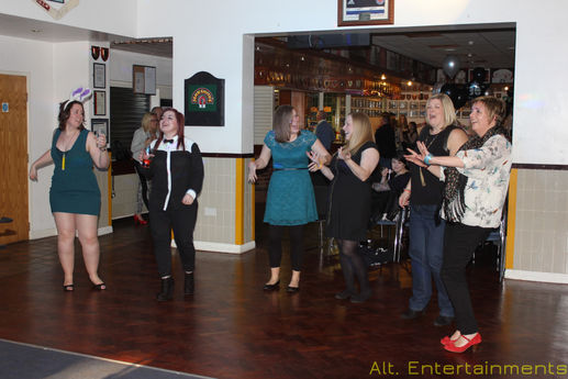 A lively birthday party at Dudley Kingswinford Rugby Club with guests dancing energetically on the dance floor. The photo, taken by Alt. Entertainments, showcases vibrant lighting and DJ equipment, capturing the festive spirit and high-energy atmosphere of the celebration.