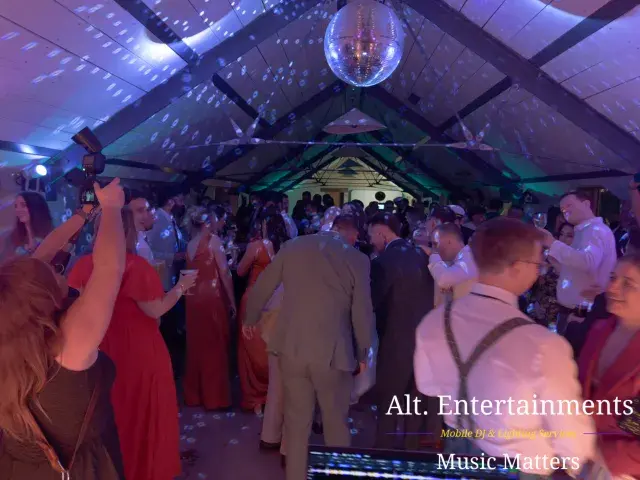 Wedding guests celebrating on the dance floor at Grangefields Barn in Ashbourne, Derbyshire, with lively music and entertainment provided by Alt. Entertainments Wedding DJ and Mobile DJ company.