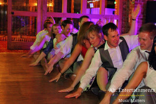 A dynamic crowd dances joyously at a wedding reception held at Mercure Madeley Telford, Shropshire. Alt. Entertainments, a trusted mobile DJ, wedding DJ, disco, and events company, captures the moment.