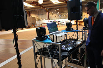 A Wedding DJ's view of a lively dancefloor inside the rustic barn at Gwaenynog Farm, near Newtown, Wales. The photo, taken by Alt. Entertainments, features dancing guests, warm string lights, and professional DJ equipment, creating a magical and intimate wedding celebration.