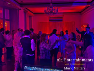 Guests dancing with enthusiasm at a wedding disco held at Garthmyl Hall, Montgomery, Wales. The photo, taken by Alt. Entertainments, showcases a lively celebration with vibrant lighting and stylish décor, featuring guests enjoying the music provided by the Mobile DJ, Wedding DJ, Indie DJ, and Alternative DJ.