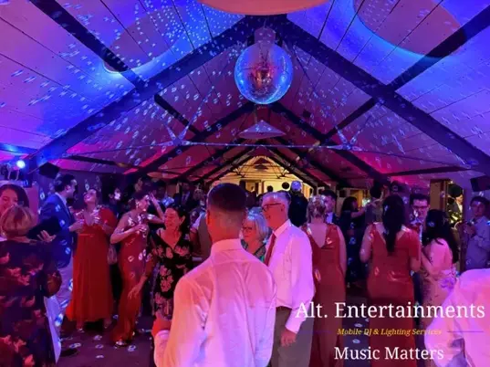 Wedding guests dancing joyfully at Grangefields Barn, Ashbourne, Derbyshire, with professional DJ and entertainment by Alt. Entertainments.