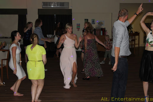 A vibrant photo of dancers enjoying a birthday party at the Beacon Centre For The Blind in Dudley, organized by Alt. Entertainments. The dancers, full of energy and joy, move dynamically on the dance floor. The DJ setup features high-powered speakers and an advanced mixing console, delivering top-quality sound. LED lights and laser effects create a colorful, synchronized light show, enhancing the festive atmosphere. The inclusive event, set in a center for the blind, highlights Alt. Entertainments' dedication to creating accessible and memorable celebrations for all guests.