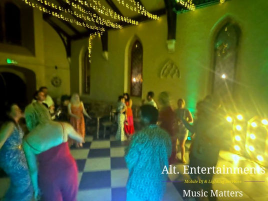 Party guests dancing joyfully on the dancefloor at a birthday celebration inside Saint James Events, a converted church venue in Pipe Ridware, Staffordshire, with music and lighting by Alt. Entertainments.