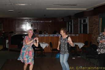 A vibrant scene of people dancing at a disco night held at Vipers RFC in Whetstone, Leicestershire. The dance floor is alive with energy as guests of all ages move to the beat. The dynamic lighting and disco ball create a magical atmosphere. Photo taken by Alt. Entertainments, a mobile DJ, disco, and events company, showcasing their expertise in creating lively and memorable events.