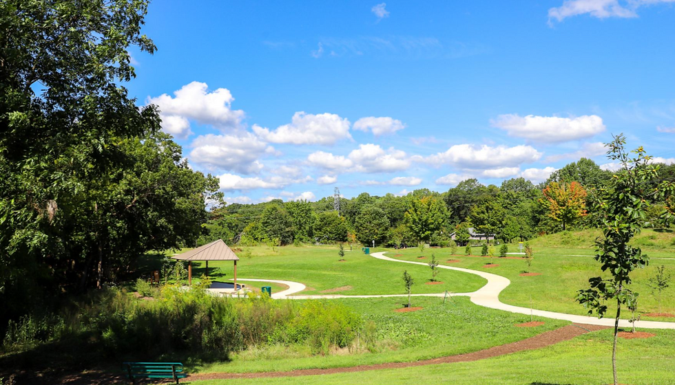 High angle view of a shaded picnic table near a creek with walking trails in the background